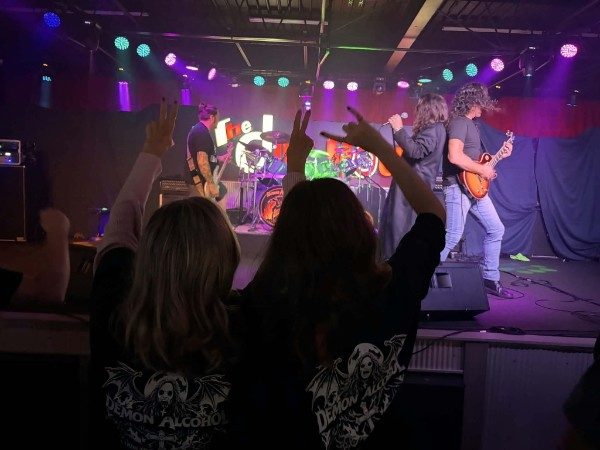 Fans with horns up in front of the stage